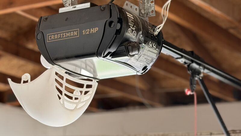 Ceiling-mounted garage door opener installed above a residential door